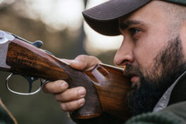 Hunter aiming with his gun in nature